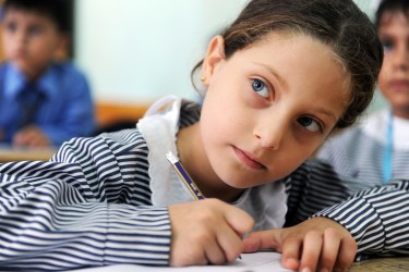 En flicka lyssnar noga under en lektion i en skola i Palestina. Foto: Shareef Sarhan, UN/Photo
