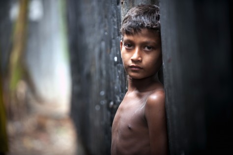 En pojke utanför sitt hem i slummorådet Karial i Bangladesh. Sipa Press/Kibae Park